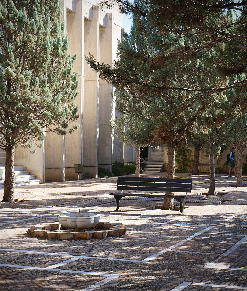 Patio exterior con fuente, zonas ajardinadas y bancos situado en la Facultad de Filosofía y Letras